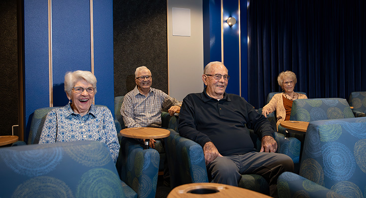 A group of senior citizens watch a movie in the modern and clean theater space at Dow Rummel